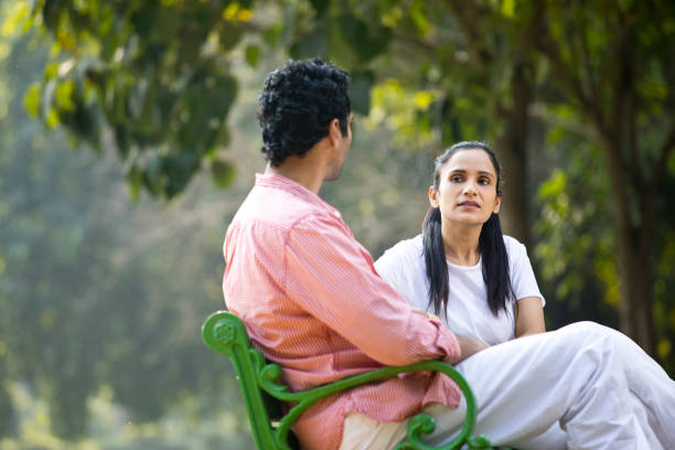 istock Couple looking at each other on park bench 1292408754