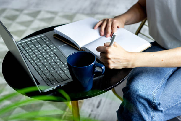 istock Woman working at home - writing in notebook 1292411808