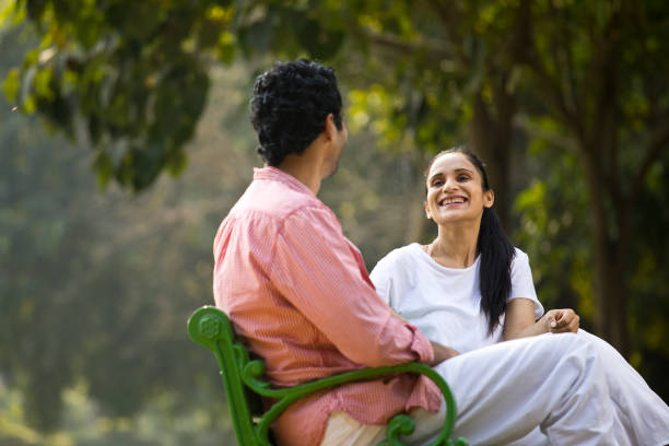 istock Couple looking at each other on park bench 1292413038