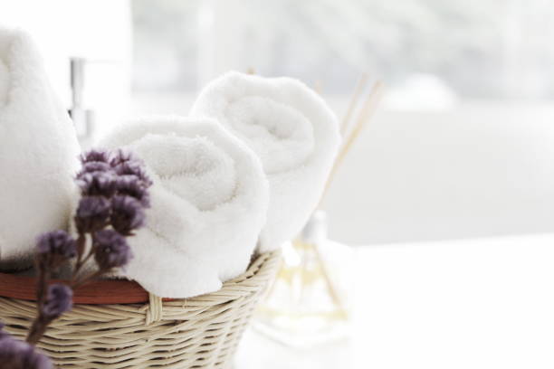 istock close up ofTowel placed on basket, white table top, bottle of liquid soap, spa set for bathing in the bathroom, copy space, bathroom window. 1292414288