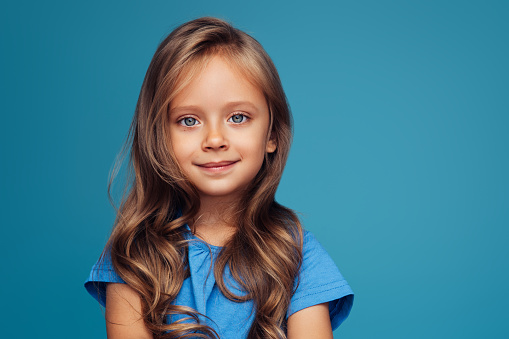 Portrait of redhead girl with freckles on summer blurred background. Cheerful and happy childhood