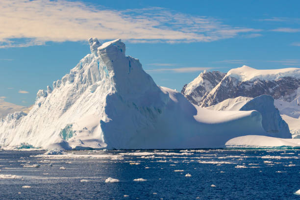 istock Large blue iceberg with mountains in the background in Antarctica. 1292415872