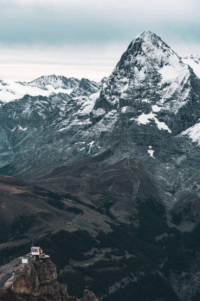 istock small cabin contrasting with huge mountain covered in snow 1292416811