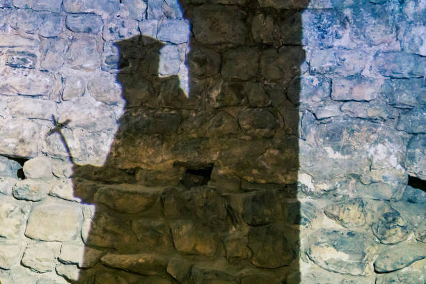 istock silhouette of a priest projected on an old stone wall 1292417246