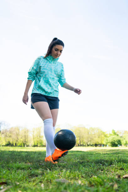 istock Young woman practicing soccer skills with ball. 1292418019