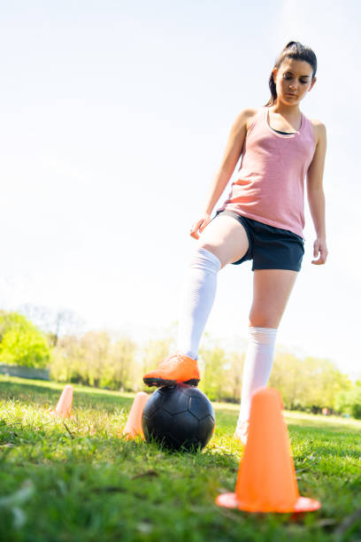 istock Young female soccer player practicing on field. 1292418051