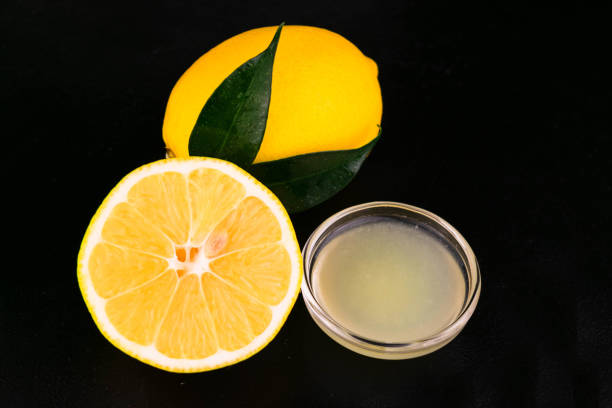 istock Lemon juice and fresh lemon on a black background. Close-up. 1292422229