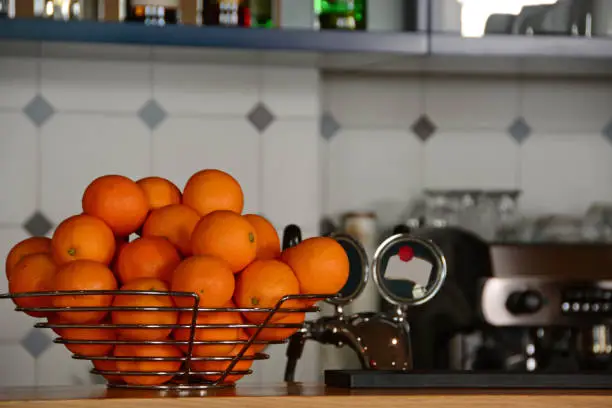 Breakfast restaurant: Group of orange fruit displayed on a counter. Aerial view of the commercial kitchen.