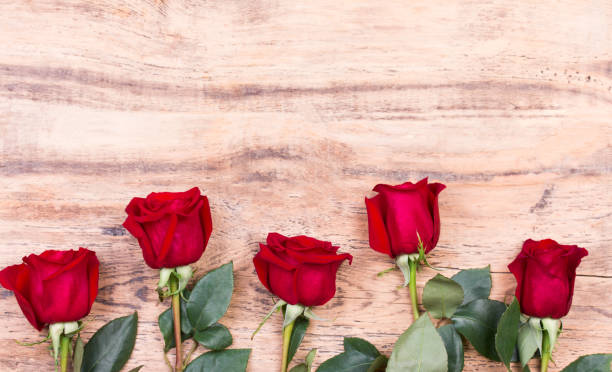istock red roses on wooden board, Valentines Day background 1292425574