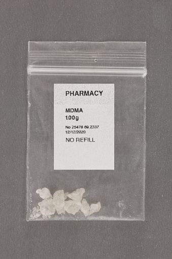 MDMA crystals in plastic bag with pharmacy label. Alternative psychotherapy. Prescription drugs.