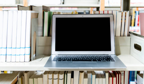 istock Blank laptop on the bookshelf of library 1292425944
