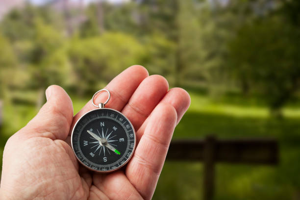 istock Hand with a Compass in the Middle of Nature 1292429657