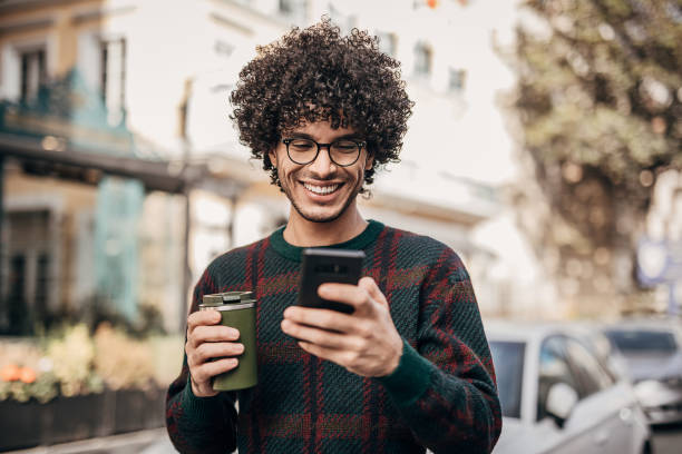 istock One handsome hipster man drinking coffee to go and using smart phone in the city 1292431146