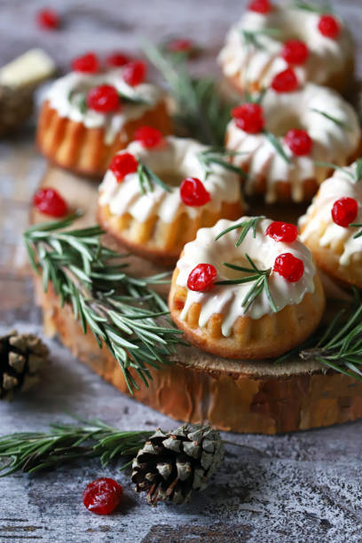 istock Christmas cakes with white icing, red berries and rosemary. 1292432783