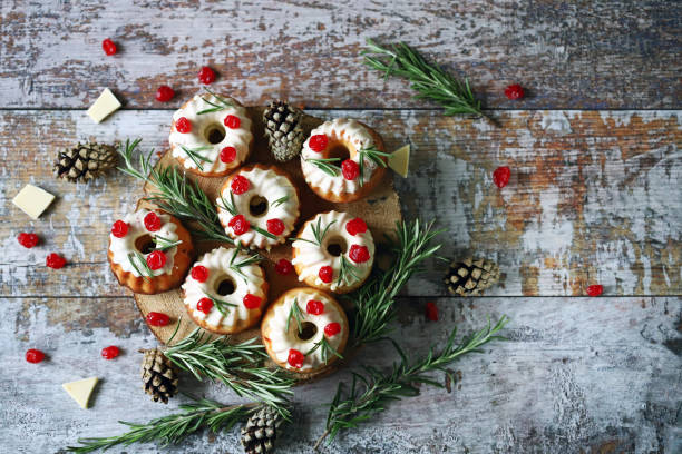 istock Christmas cakes with white icing, red berries and rosemary. 1292432796