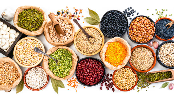 Large variety of dried beans, legumes and cereals shot from above on white background Food Backgrounds: large variety of dried beans, legumes and cereals shot from above on white background. The composition includes green, yellow and brown lentils, chick-peas, black beans, Pinto beans, Kidney beans, fava beans, mung beans, white beans and soy beans among others. High resolution 35,5Mp studio digital capture taken with SONY A7rII and Zeiss Batis 40mm F2.0 CF lens legume family stock pictures, royalty-free photos & images