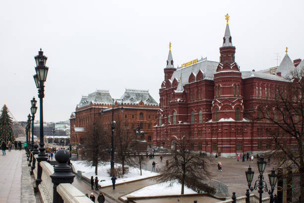 view of the building of the historical Museum and the square with lanterns panoramic view of the building of the historical Museum and the square with lanterns on Okhotny Ryad on a cloudy winter day in Moscow historical museum stock pictures, royalty-free photos & images
