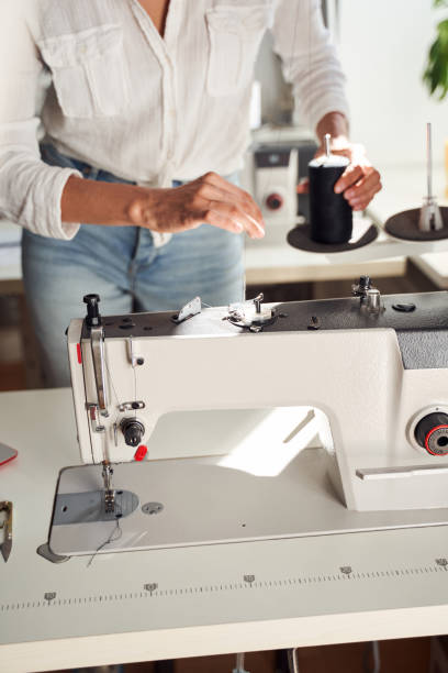 istock Woman seamstress sewing on sewing machine 1292434691