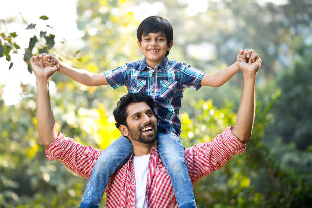 istock Father carrying son on shoulder at park 1292435613