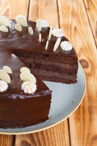 istock Cut chocolate cake on plate on wooden table 1292439130