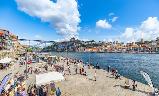 la gente gode del sole e del caldo sulla banchina lungo il fiume di porto. portogallo - porto built structure commercial dock port wine foto e immagini stock