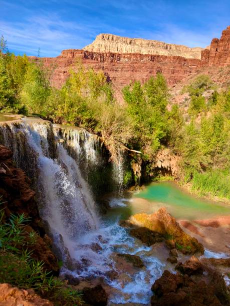 istock Waterfall into a green river and red canyon 1292441445