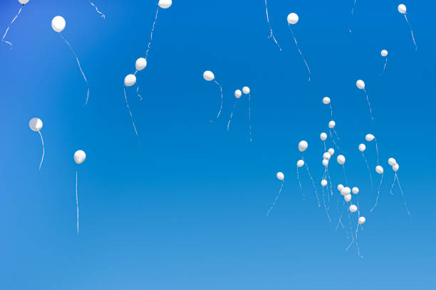 istock White balloons flying in the blue sky 1292441612