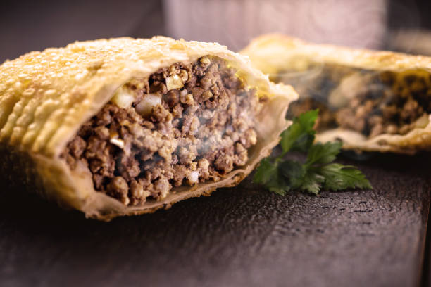 fried meat pastry cut in half, stuffed with minced meat and potatoes and hot sauce. Typical food in the city of São Paulo stock photo