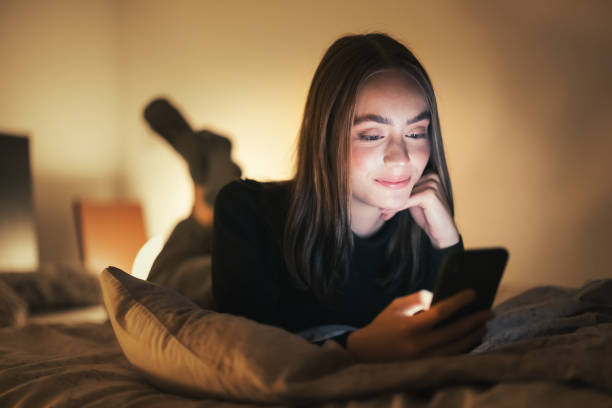 istock Woman relaxing on bed at night using her smart phone 1292442568