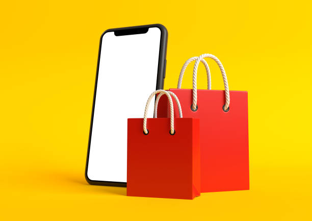 istock Red Shopping bags with empty smartphone screen on a yellow background 1292443586