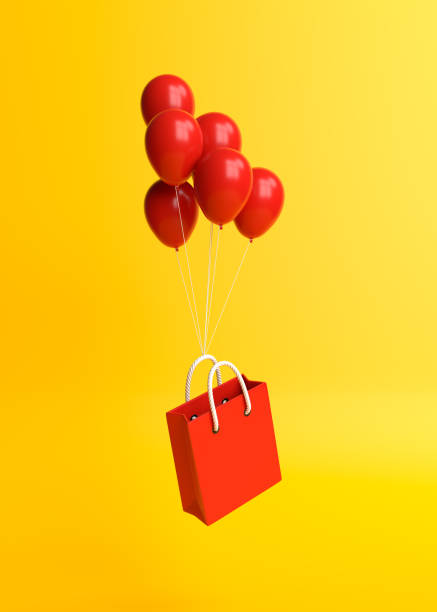 istock Flying shopping bag with balloons on a yellow background 1292443604