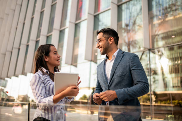 Two colleagues are talking in front of the building