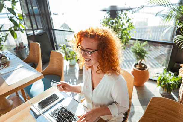 istock Redhead woman using laptop in cafe online shopping 1292450879
