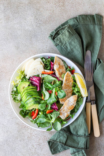 insalata di mix fresco con filetto di pollo alla griglia, avocado, mela e peperone e olio d'oliva e condimento al limone. cibo sano, dieta che mangia. vista dall'alto. - chicken salad chicken salad apple foto e immagini stock