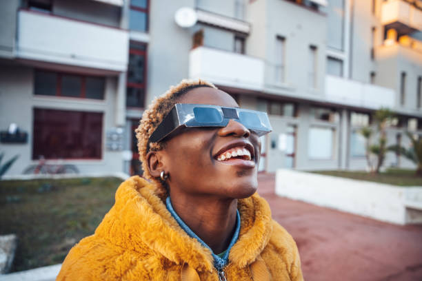 teenage girl looking at solar eclipse - eclipse imagens e fotografias de stock