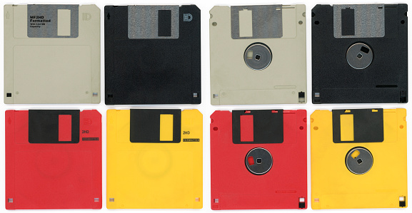 Fronts and backs of gray, black, red and yellow 3 1/4 inch floppy discs isolated on white.