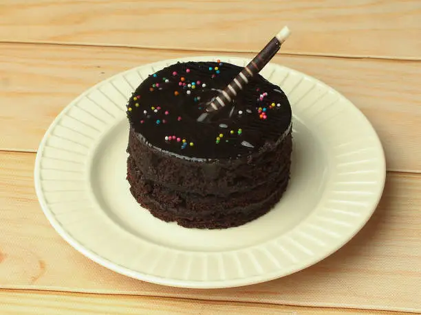 Tasty dark chocolate cake on white plate for birthday celebration