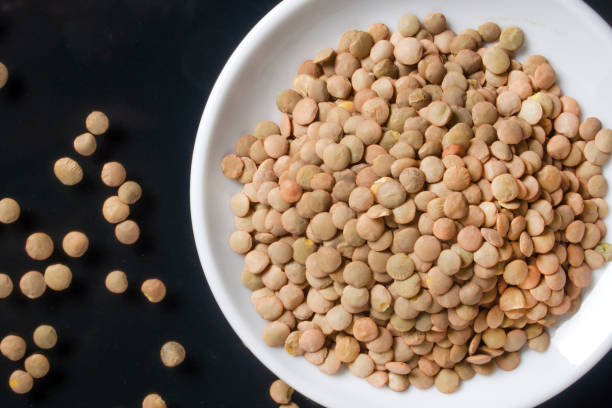 istock lentils on a white plate, the plate is on a glass table 1292454427