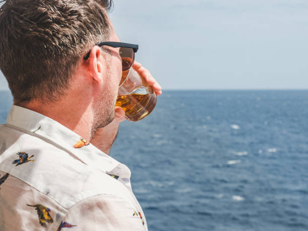 istock Fashionable man holding a beautiful glass on the open deck 1292460940