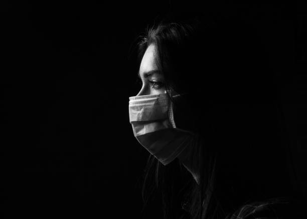 Beautiful brunette girl in a protective mask Beautiful brunette girl in a protective mask on a black background avian flu virus photos stock pictures, royalty-free photos & images