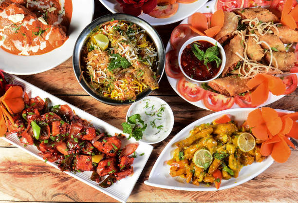 istock Assorted indian food on wooden background.Mutton biryani,lemon chicken,chilli chicken and spring roll.. Dishes and appetizers of indian cuisine 1292462637