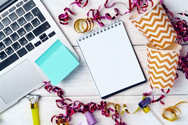 istock Office desk with laptop and open notepad decorated with party streamers 1292468400