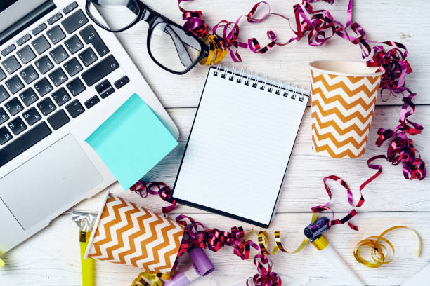 istock Office desk with laptop and open notepad decorated with party streamers 1292469645