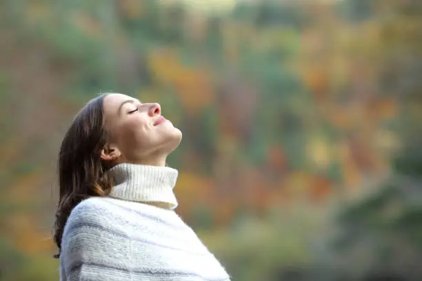 Woman breathing fresh air in the mountain in winter