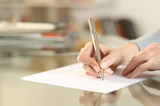 istock Woman hands writing letter on paper sheet on table 1292470767