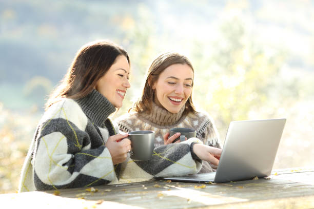 dos amigos felices usando portátil en invierno en un parque - mountain stream fotografías e imágenes de stock