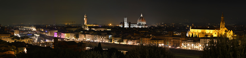 Florence, December 2020: Cityscape of Florence at evening with Old Bridge, Palace of Townhall, Cathedral of Santa Maria del Fiore and Basilica of the Holy Cross illuminated during Christmas period. Italy.