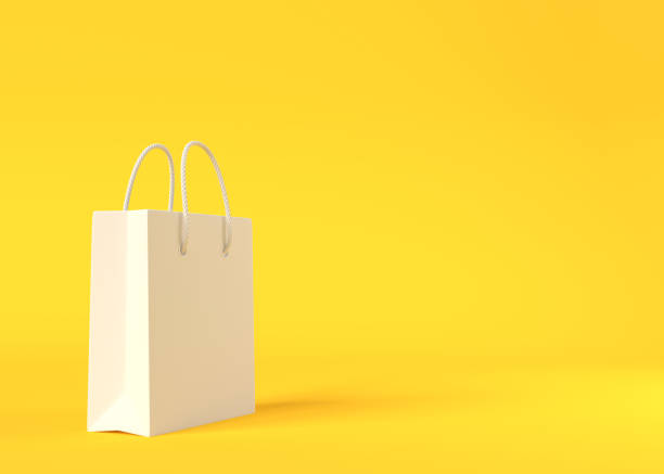 istock Empty white color shopping bag on the yellow background 1292474516