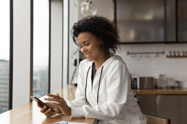 istock Smiling biracial woman use modern smartphone at home 1292475577