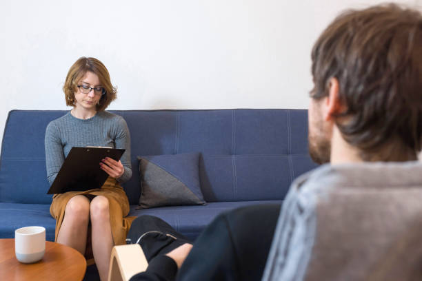 istock Female psychologist takes notes during a session of psychological therapy. A man with problems came to a consultation with his doctor. Mental health concept. 1292476141